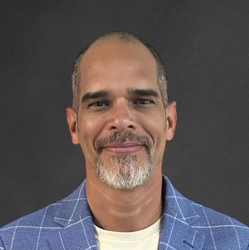 Portrait of Adel Suarez in a blue plaid jacket